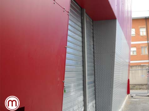 Facciata per un locale pubblico in lameria verniciata rossa, con viteria a vista e grecata a onde